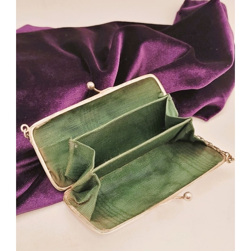 65 - AN EARLY 20TH CENTURY SILVER CLUTCH PURSE, the rounded rectangular silver body has a ball clasp that... 