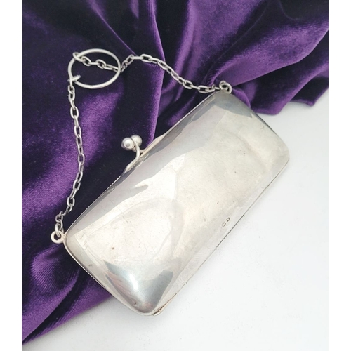 65 - AN EARLY 20TH CENTURY SILVER CLUTCH PURSE, the rounded rectangular silver body has a ball clasp that... 