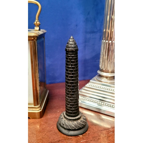 66 - A CARVED IRISH BOG OAK ROUND TOWER ORNAMENT, with domed top and carved brick detail to the tower, al... 