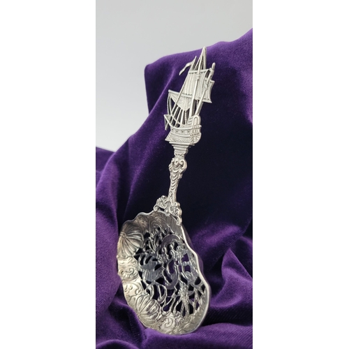 72 - A VERY FINELY CRAFTED STERLING SILVER PIECED BERRY / SIFTER SPOON, the tip of the handle in the form... 