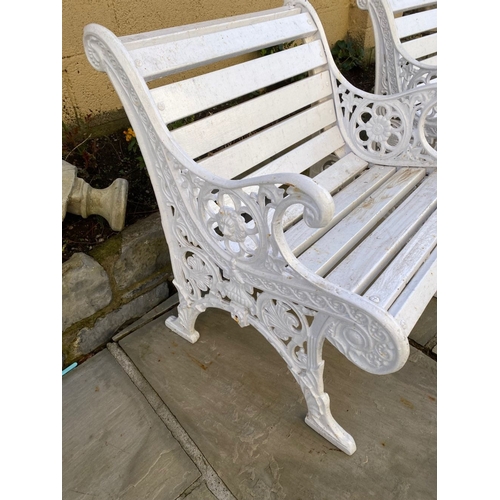 77 - A PAIR OF CAST IRON GARDEN BENCHES, with wooden splat back, cast iron curved openwork supports with ... 