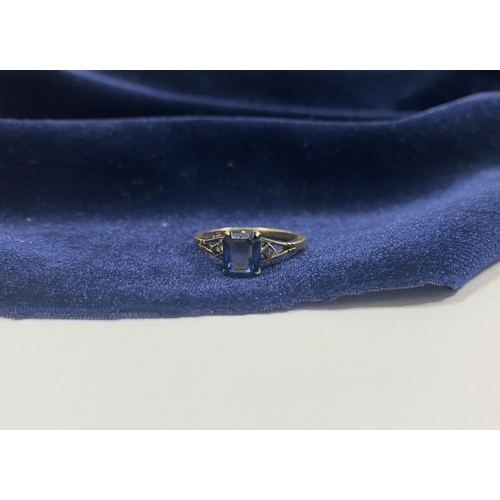 80 - A PRETTY 9CT GOLD PLATED SAPPHIRE RING, large emerald cut sapphire in claw setting, flanked by marca... 