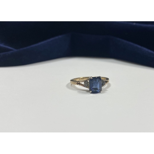 80 - A PRETTY 9CT GOLD PLATED SAPPHIRE RING, large emerald cut sapphire in claw setting, flanked by marca... 