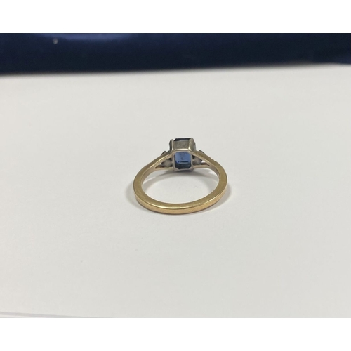 80 - A PRETTY 9CT GOLD PLATED SAPPHIRE RING, large emerald cut sapphire in claw setting, flanked by marca... 