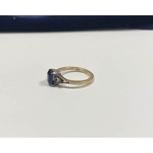 80 - A PRETTY 9CT GOLD PLATED SAPPHIRE RING, large emerald cut sapphire in claw setting, flanked by marca... 