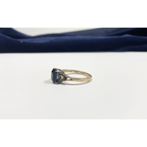 80 - A PRETTY 9CT GOLD PLATED SAPPHIRE RING, large emerald cut sapphire in claw setting, flanked by marca... 