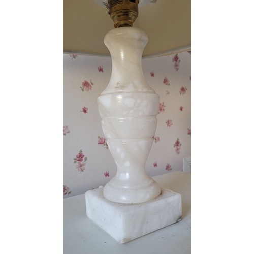 83 - A SMALL TURNED ALABASTER TABLE LAMP / BEDSIDE LAMP, with a shade. Dimensions: 39.5cm tall with shade... 