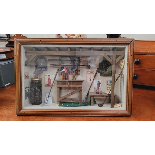 182 - A FRAMED GOLF SHADOWBOX, filled with miniature ornamental items relating to the sport of golf. Conte... 