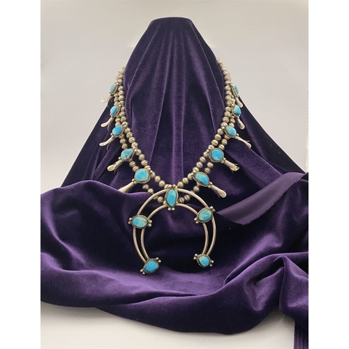 215 - A VINTAGE NAVAJO STERLING SILVER TURQUOISE SQUASH BLOSSOM NECKLACE, with two rows of beads to neckla... 