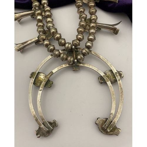 215 - A VINTAGE NAVAJO STERLING SILVER TURQUOISE SQUASH BLOSSOM NECKLACE, with two rows of beads to neckla... 