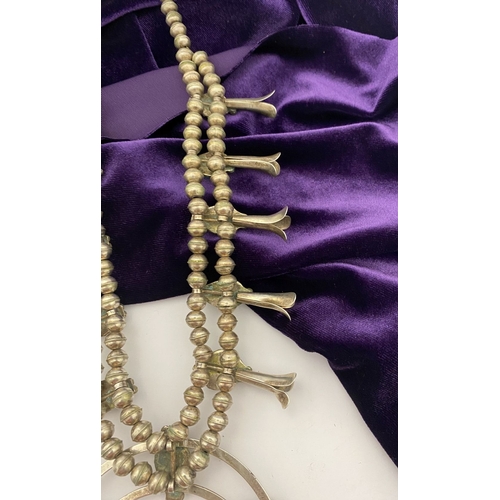 215 - A VINTAGE NAVAJO STERLING SILVER TURQUOISE SQUASH BLOSSOM NECKLACE, with two rows of beads to neckla... 