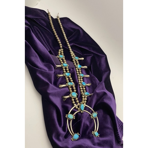 215 - A VINTAGE NAVAJO STERLING SILVER TURQUOISE SQUASH BLOSSOM NECKLACE, with two rows of beads to neckla... 