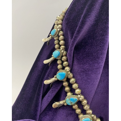 215 - A VINTAGE NAVAJO STERLING SILVER TURQUOISE SQUASH BLOSSOM NECKLACE, with two rows of beads to neckla... 