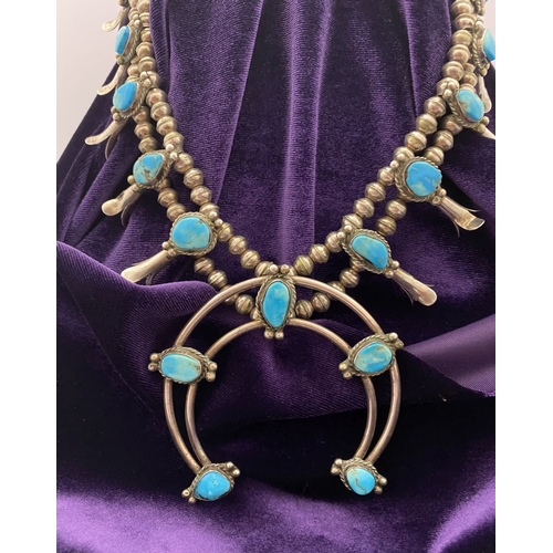 215 - A VINTAGE NAVAJO STERLING SILVER TURQUOISE SQUASH BLOSSOM NECKLACE, with two rows of beads to neckla... 