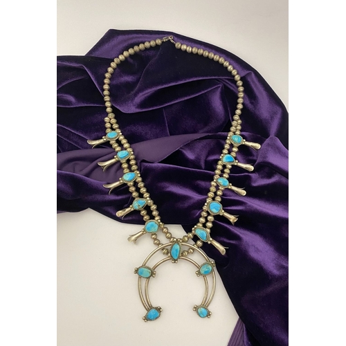 215 - A VINTAGE NAVAJO STERLING SILVER TURQUOISE SQUASH BLOSSOM NECKLACE, with two rows of beads to neckla... 