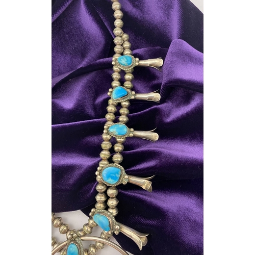 215 - A VINTAGE NAVAJO STERLING SILVER TURQUOISE SQUASH BLOSSOM NECKLACE, with two rows of beads to neckla... 