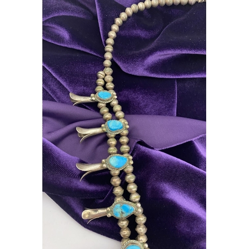 215 - A VINTAGE NAVAJO STERLING SILVER TURQUOISE SQUASH BLOSSOM NECKLACE, with two rows of beads to neckla... 