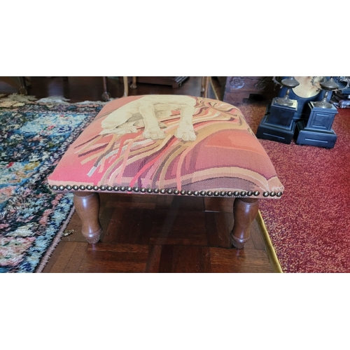 222 - A LOW RISE FRENCH FOOT STOOL, with upholstered top depicting a terrier, raised on turned leg finishe... 