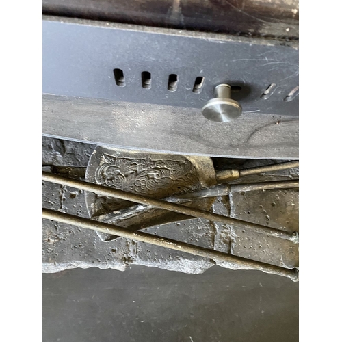 225 - A DECORATIVE BRASS FIRE IMPLEMENTS SET, to include a pair of andirons, shovel, poker and tongs. All ... 