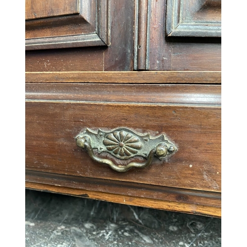 234 - AN ANTIQUE MAHOGANY HANGING CABINET, with shaped reeded border to top above two panelled doors over ... 