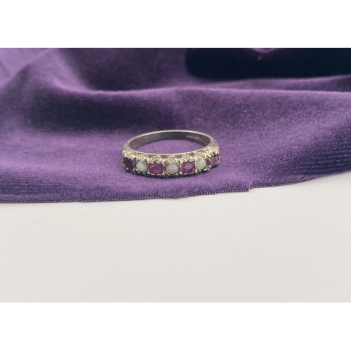 241 - A LOVELY SILVER OPAL & PINK GEMSTONE SEVEN STONE RING, with four round cut pink gemstones separated ... 