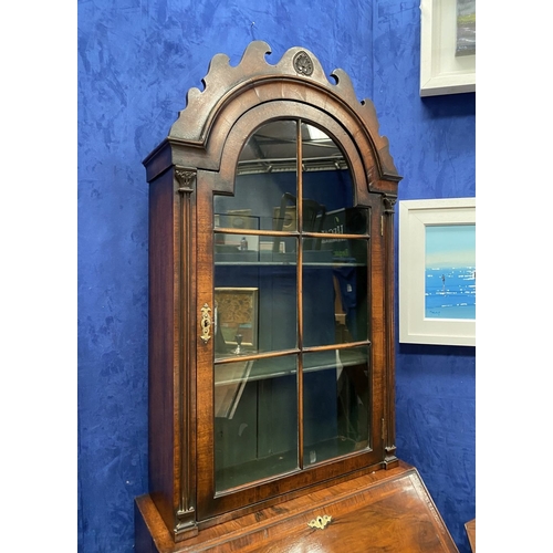 25 - A MAHOGANY QUEEN ANNE STYLE BUREAU BOOKCASE, the carved pediment to arched top with shell motif to c... 