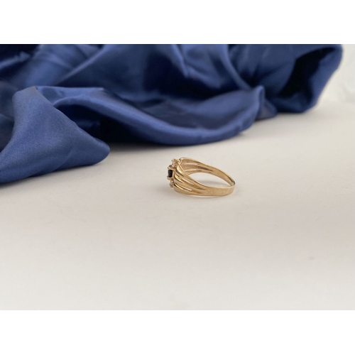 254 - A PRETTY IRISH 9CT GOLD THREE STONE RING, central round cut blue gemstone with two round cut clear g... 
