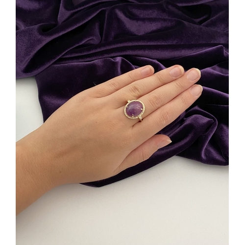 35 - A STRIKING 14CT YELLOW GOLD OVAL CABOCHON RUBY & DIAMOND CLUSTER RING, with central oval cabochon cu... 