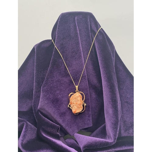 48 - A BEAUTIFUL 9CT GOLD ORANGE CORAL PENDANT NECKLACE WITH DIAMONDS, finely carved orange coral bust ho... 