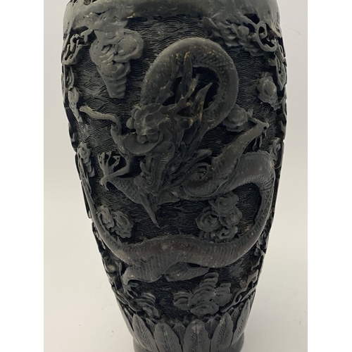 91 - A CHINESE CARVED BLACK CINNABAR LACQUER VASE, the body decorated with incised dragon and smoke motif... 
