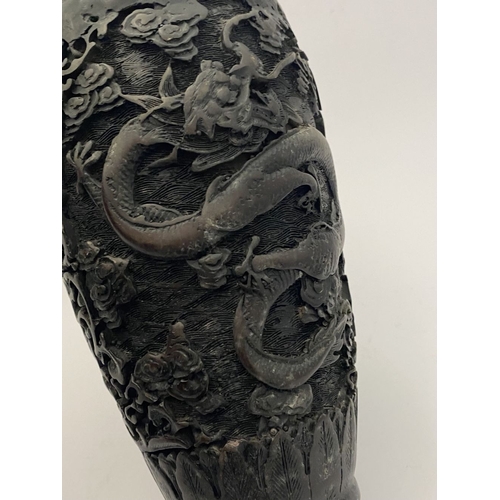 91 - A CHINESE CARVED BLACK CINNABAR LACQUER VASE, the body decorated with incised dragon and smoke motif... 