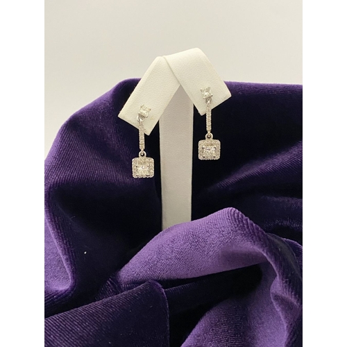 13 - AN ELEGANT PAIR OF 14CT WHITE GOLD DIAMOND DROP EARRINGS, each featuring princess cut diamonds above... 