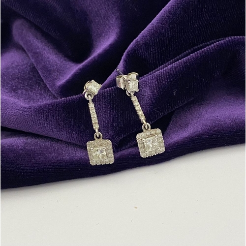 13 - AN ELEGANT PAIR OF 14CT WHITE GOLD DIAMOND DROP EARRINGS, each featuring princess cut diamonds above... 