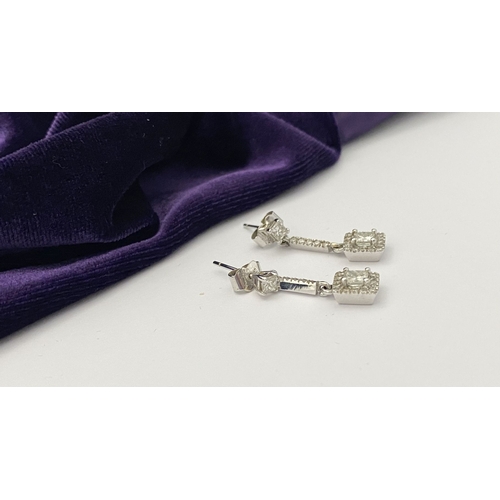 13 - AN ELEGANT PAIR OF 14CT WHITE GOLD DIAMOND DROP EARRINGS, each featuring princess cut diamonds above... 