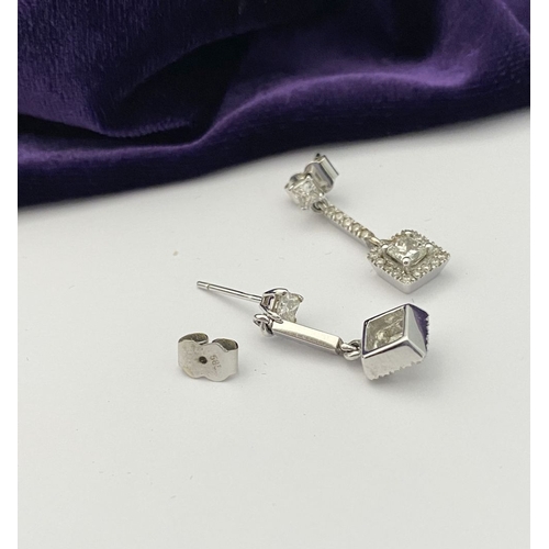 13 - AN ELEGANT PAIR OF 14CT WHITE GOLD DIAMOND DROP EARRINGS, each featuring princess cut diamonds above... 