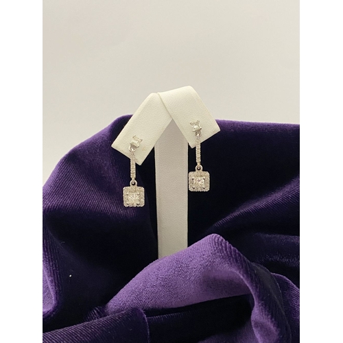 13 - AN ELEGANT PAIR OF 14CT WHITE GOLD DIAMOND DROP EARRINGS, each featuring princess cut diamonds above... 