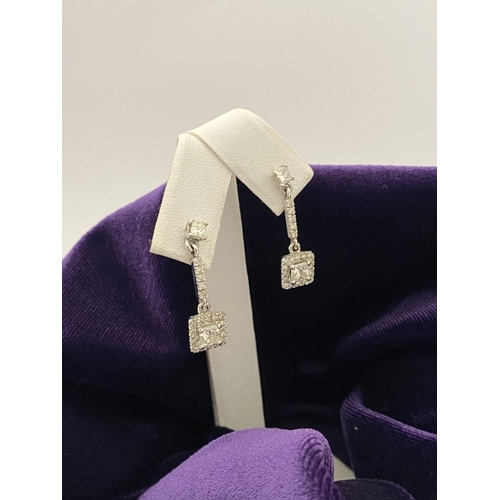 13 - AN ELEGANT PAIR OF 14CT WHITE GOLD DIAMOND DROP EARRINGS, each featuring princess cut diamonds above... 