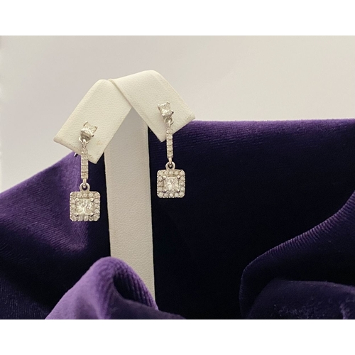 13 - AN ELEGANT PAIR OF 14CT WHITE GOLD DIAMOND DROP EARRINGS, each featuring princess cut diamonds above... 