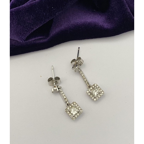 13 - AN ELEGANT PAIR OF 14CT WHITE GOLD DIAMOND DROP EARRINGS, each featuring princess cut diamonds above... 