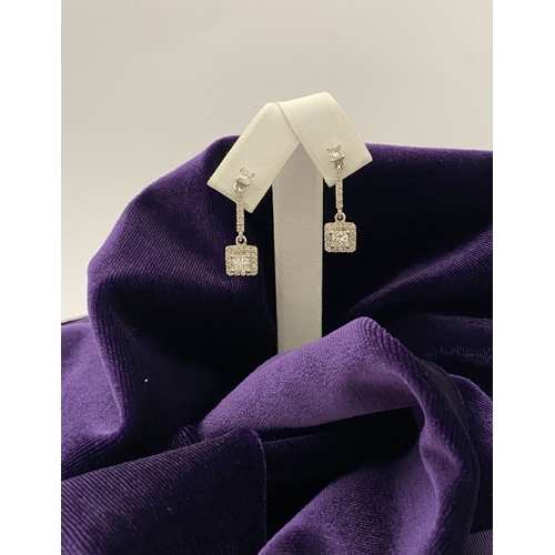 13 - AN ELEGANT PAIR OF 14CT WHITE GOLD DIAMOND DROP EARRINGS, each featuring princess cut diamonds above... 