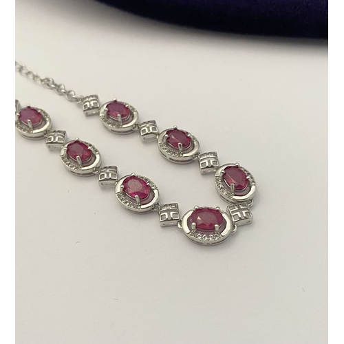 18 - AN ELEGANT 18CT GOLD PLATED RUBY BRACELET, featuring seven oval cut rubies, clarity enhanced for exc... 