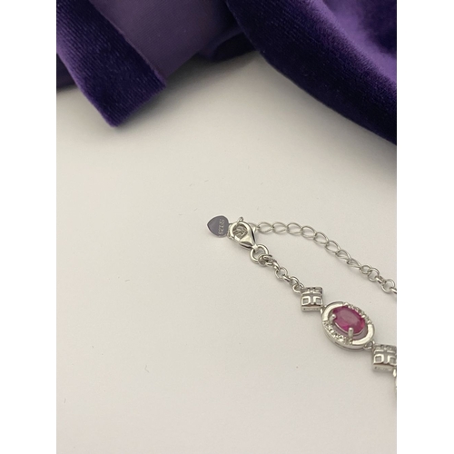 18 - AN ELEGANT 18CT GOLD PLATED RUBY BRACELET, featuring seven oval cut rubies, clarity enhanced for exc... 