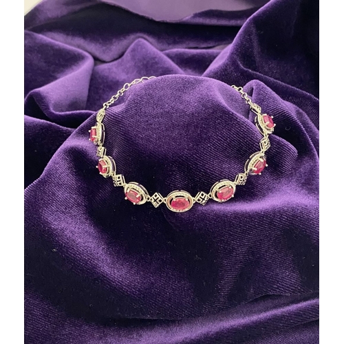 18 - AN ELEGANT 18CT GOLD PLATED RUBY BRACELET, featuring seven oval cut rubies, clarity enhanced for exc... 