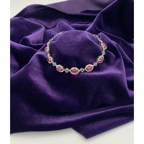 18 - AN ELEGANT 18CT GOLD PLATED RUBY BRACELET, featuring seven oval cut rubies, clarity enhanced for exc... 