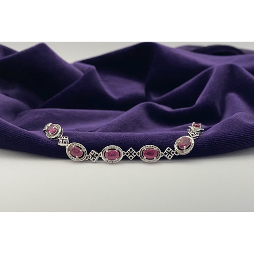 18 - AN ELEGANT 18CT GOLD PLATED RUBY BRACELET, featuring seven oval cut rubies, clarity enhanced for exc... 