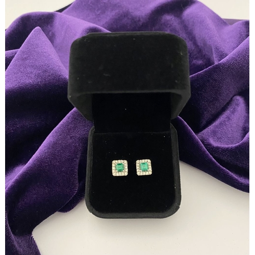 27 - A STUNNING PAIR OF 14CT WHITE GOLD EMERALD & DIAMOND STUD EARRINGS, with central vibrant emerald in ... 