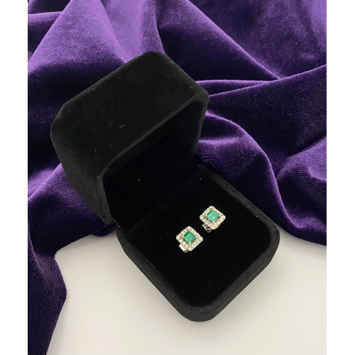 27 - A STUNNING PAIR OF 14CT WHITE GOLD EMERALD & DIAMOND STUD EARRINGS, with central vibrant emerald in ... 
