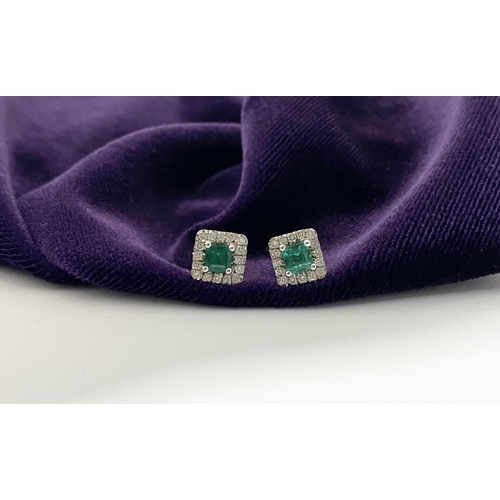 27 - A STUNNING PAIR OF 14CT WHITE GOLD EMERALD & DIAMOND STUD EARRINGS, with central vibrant emerald in ... 
