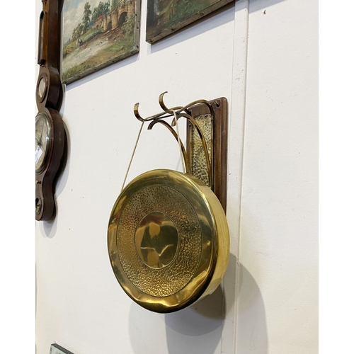 46 - A BRASS WALL HANGING DINNER GONG, wall mountable hardwood stand, with brass hanging hooks and hammer... 