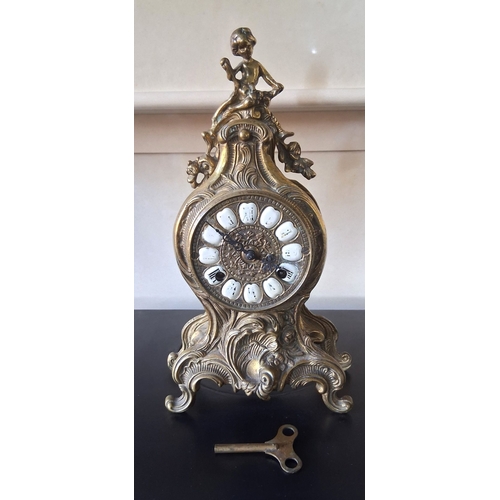 55 - A LOUIS XV STYLE BRASS FRANZ HERMLE MANTLE CLOCK, intricate piece with figural putti finial, raised ... 